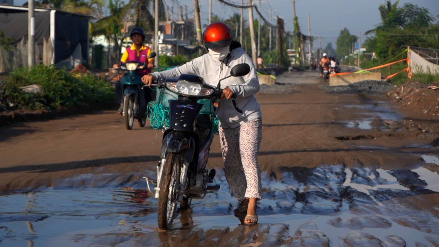 Vì khó đi, người phụ nữ này phải xuống xe dắt bộ. Ảnh: Tạ Quang