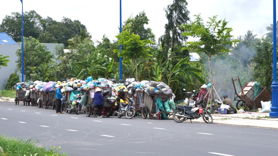 Tại ngay vòng xoay Võ Văn Kiệt đến đường Cách mạng Tháng 8, tuyến này có điểm tập kết rác, nhiều xe rác đậu tại đây. Đáng chú ý, sau khi chở rác về điểm tập kết trên đường, một số loại rác đã được nhân viên thu gom đốt ngay tại chỗ.