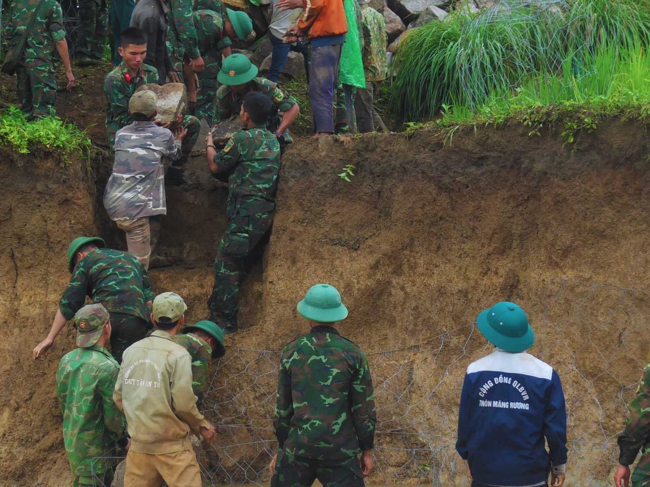 Bằng sự đoàn kết, đồng lòng của người dân và các chiến sĩ, từng lượt đá được di chuyển thuận lợi vào các vị trị sạt lở. Ảnh: Lê Nguyên