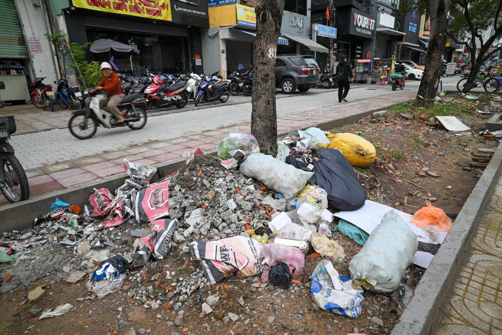 Những bao rác sinh hoạt, xà bần đủ loại... chất đống ở vỉa hè khu vực Quận 1 gây mất mĩ quan đô thị. Ảnh: Minh Tâm